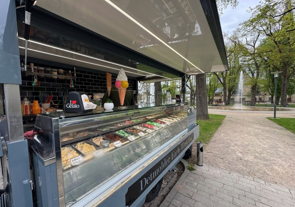 Ein moderner blauer Eisladen mit bunter Auswahl und Eiswaffeln in der Auslage